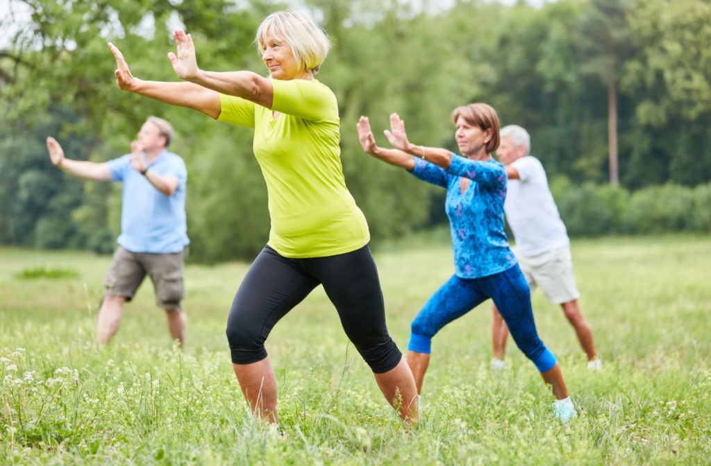 A group of older adults doing Tai Chi outdoors